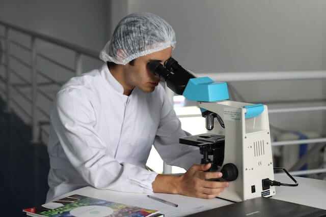 Lab man examining some samples in white uniform